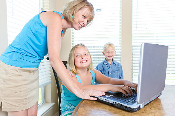Mom helps children with Computer stock photo