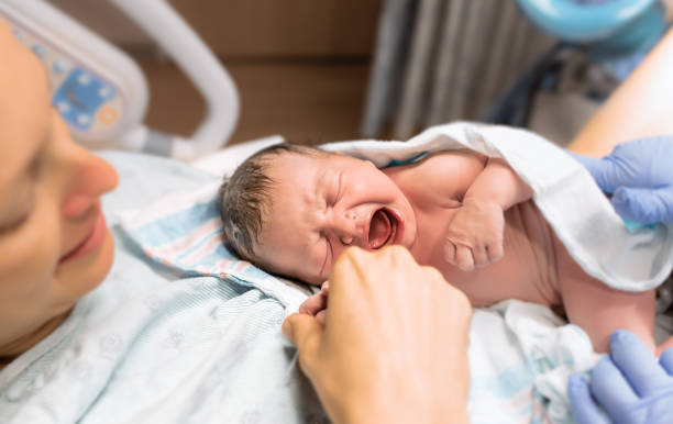 Mom holds her baby in the hospital stock photo