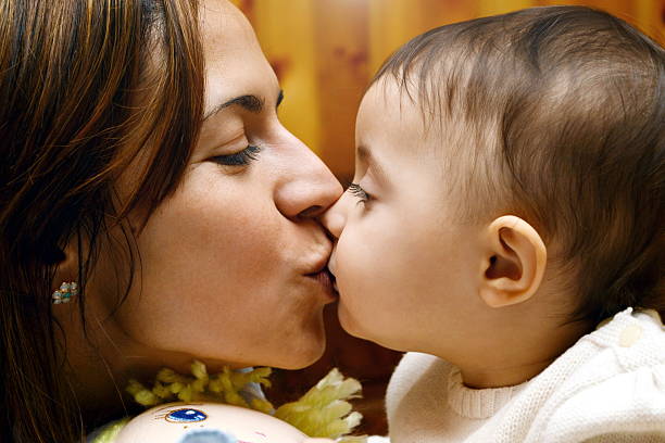 mom kissing baby  kissing baby in lips stock pictures, royalty-free photos & images