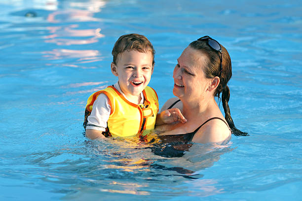 Mom swimming with autistic son stock photo
