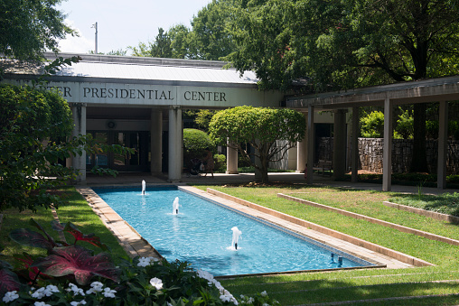 Atlanta, USA - August 14, 2017. A mom with her baby in stroller by the fountain pool at Jimmy Carter Presidential Center in Atlanta, Georgia. The Jimmy Carter Presidential Center or Library and Museum houses papers and other materials of former president Jimmy Carter relevant to his administration and family life.