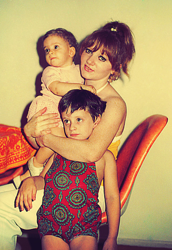 Vintage  photo from the seventies featuring a mother and hugging her daughter and son