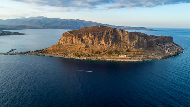 Monemvasia on Peloponnese, Greece Monemvasia, small rocky peninsula next to Peloponnese with small settlement in Greece. Aerial view made with drone before sunset, with soft sunlight laconia greece stock pictures, royalty-free photos & images