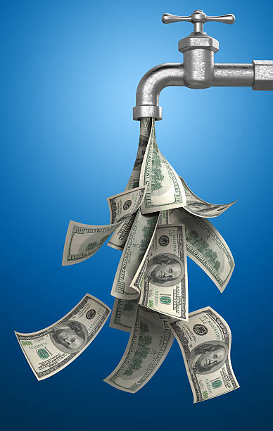 Money Bills Pouring Out of Water Tap on Blue Background stock photo