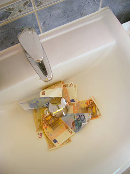 Money down the drain stock photo