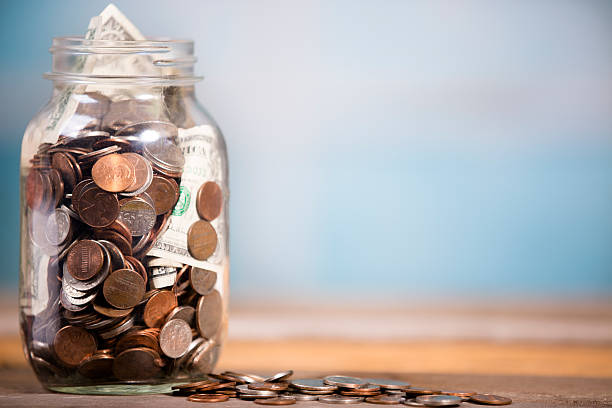money jar with u.s. currency.  savings, donations concepts. - glazen pot stockfoto's en -beelden