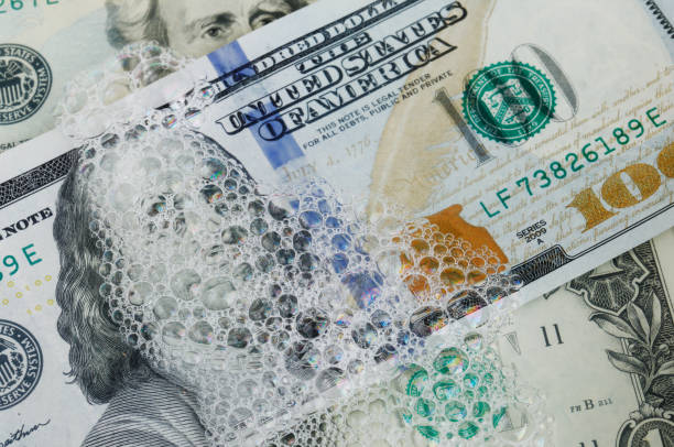 Money laundering Full frame image of US dollar currency banknotes in various denominations in soap water. money laundering stock pictures, royalty-free photos & images
