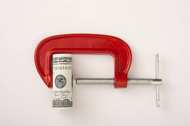 Money roll clamped in a red clamp on a white background stock photo
