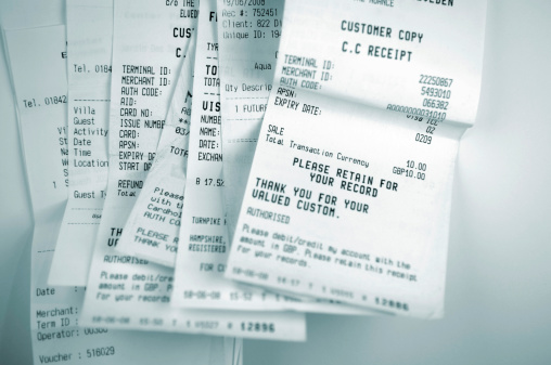 blue selective focus image of till receipts