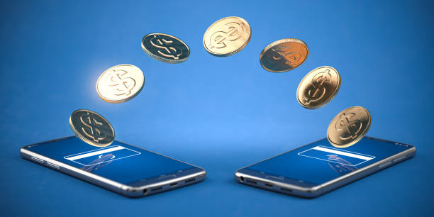 Money transfer and mobile online transaction with smartphones  or mobile phones with coins. stock photo