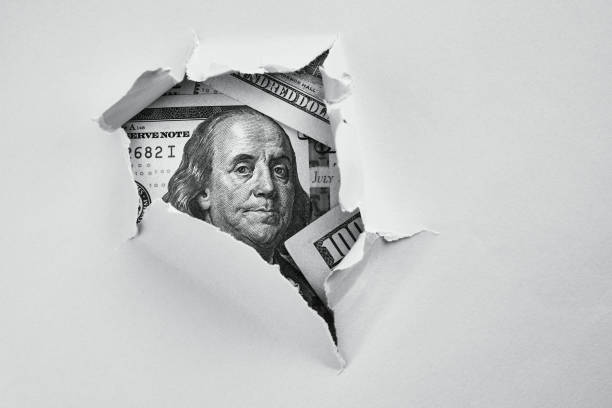 Money under holed paper Bill of one hundred dollars under holed paper benjamin franklin stock pictures, royalty-free photos & images