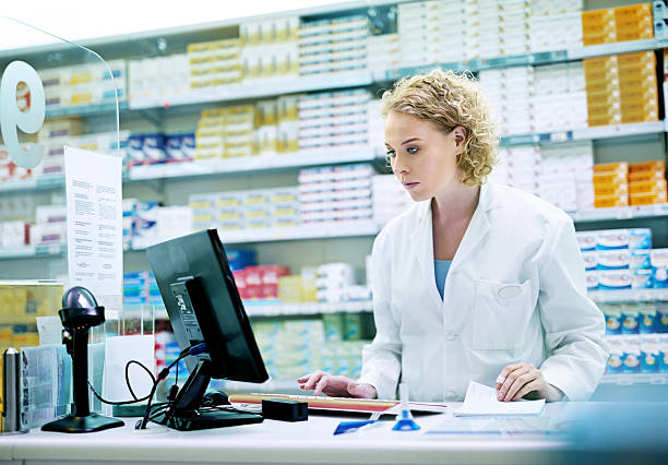 monitoring daily operations of the pharmacy with modern technology - balcão computador imagens e fotografias de stock