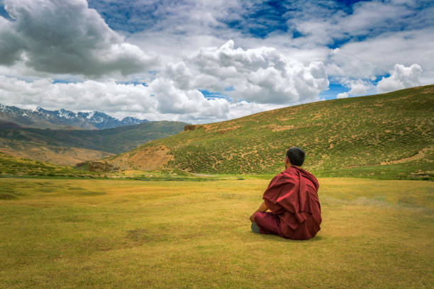 monk sitting  alone on ground in a valley monk sitting  alone on ground in a valley near spiti, india tibetan culture stock pictures, royalty-free photos & images