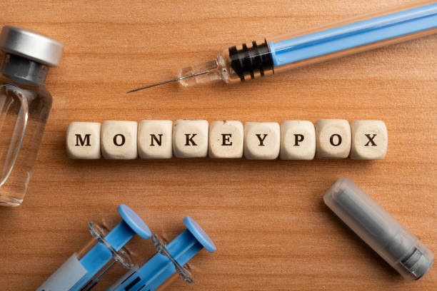 monkeypox pandemic concept: dice surrounded by syringes and vials make up the word monkeypox - monkeypox stockfoto's en -beelden