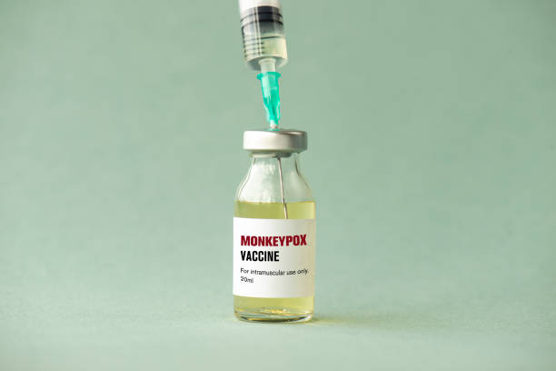 Monkeypox Vaccine Vaccine glass bottle and syringe, green background. monkeypox vaccine stock pictures, royalty-free photos & images