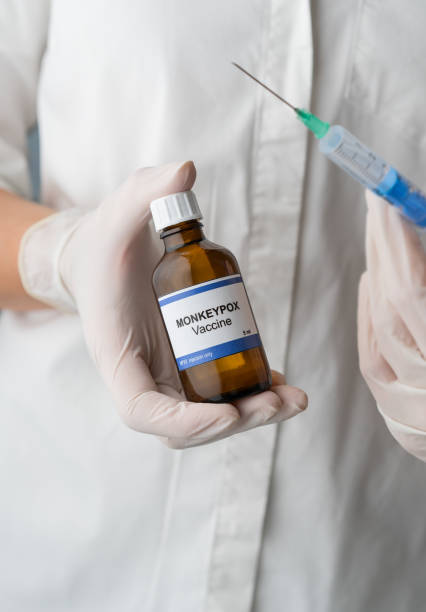 texto del virus monkeypox en botella en la mano de los médicos - monkeypox vaccine fotografías e imágenes de stock