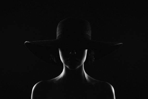 Monochrome studio shot of young beautiful woman wearing hat stock photo
