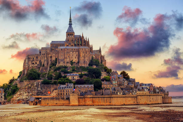 Mont Saint Michel island, Normandy, France, on sunset Le Mont Saint Michel island, one of the most visited historical sites in France, on dramatic sunset manche stock pictures, royalty-free photos & images