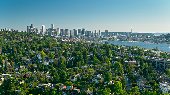 Aerial shot of the Montlake neighborhood of Seattle, Washington on a sunny afternoon in summer, with the downtown skyline in the background.