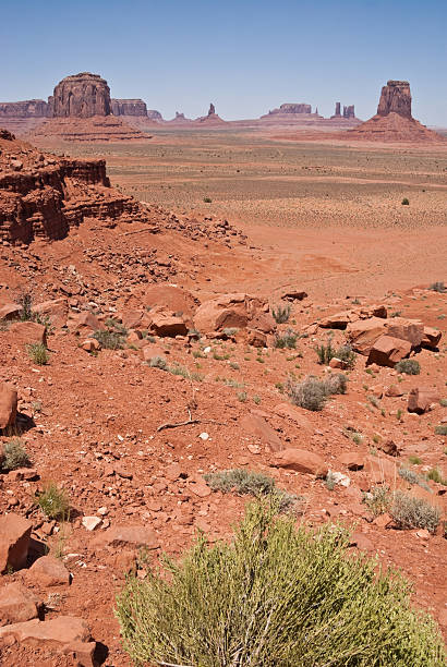 Monument Valley from North Window Overlook Monument Valley, on the Arizona - Utah border, gives us some of the most iconic and enduring images of the American Southwest. The harsh empty desert is punctuated by many colorful sandstone rock formations. It can be a photographer's dream to capture the ever-changing play of light on the buttes and mesas. Even to the first-time visitor, Monument Valley will probably seem very familiar. This rugged landscape has achieved fame in the movies, advertising and brochures. It has been filmed and photographed countless times over the years. If a movie producer was looking for a landscape that epitomizes the Old West, a better location could not be found. This picture of Monument Valley was photographed from North Window Overlook off the Monument Valley Road north of Kayenta, Arizona, USA. jeff goulden monument valley stock pictures, royalty-free photos & images