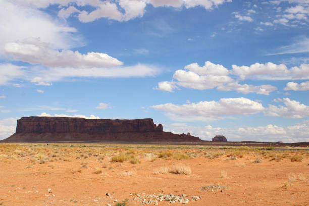 Monument Valley Landscape of Natural Rock Formations and Blue Sky with White Clouds stock photo