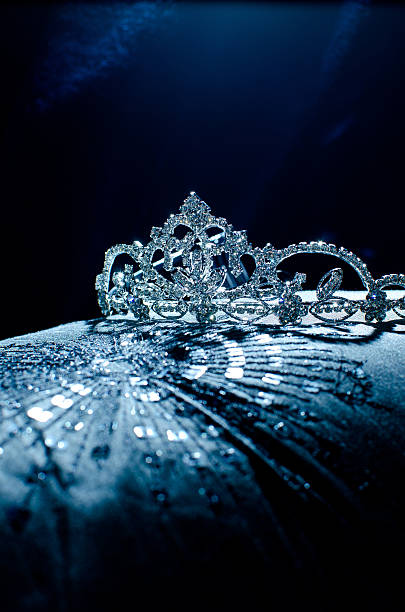 Moody photo of a tiara presented on a pillow Festive chrystal tiara shining on a pillow beauty pageant stock pictures, royalty-free photos & images