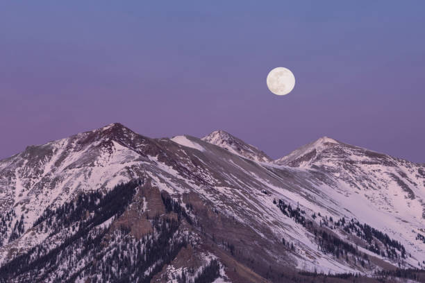 Moon Over Snowy Peaks stock photo
