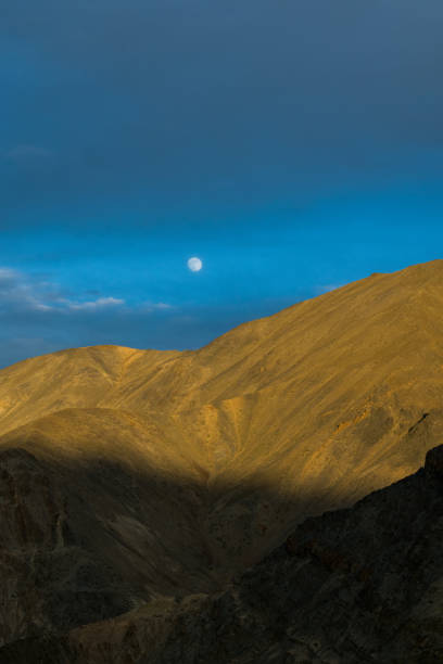 Moonrise and Sunset in Lamayuru Kashmir - Moonland of Ladakh Moonrise in the east, the sunset light falling on the mountains. leh district stock pictures, royalty-free photos & images