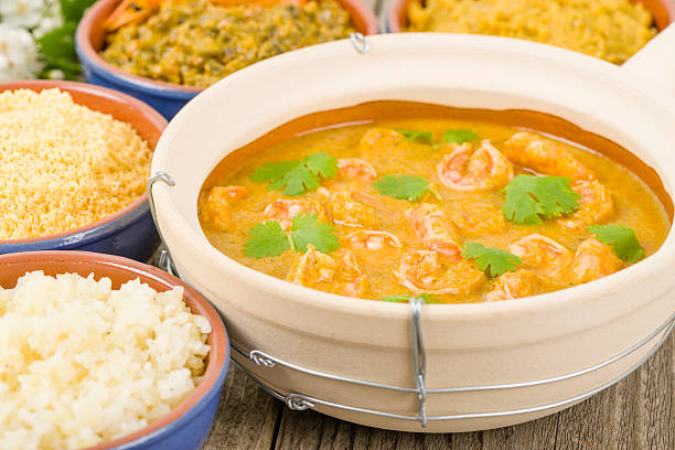 Moqueca de Camarao Brazilian prawns in coconut milk and dende oil. Served with caruru, vatapa, farofa and rice. Food from Bahia. okra plants pics stock pictures, royalty-free photos & images