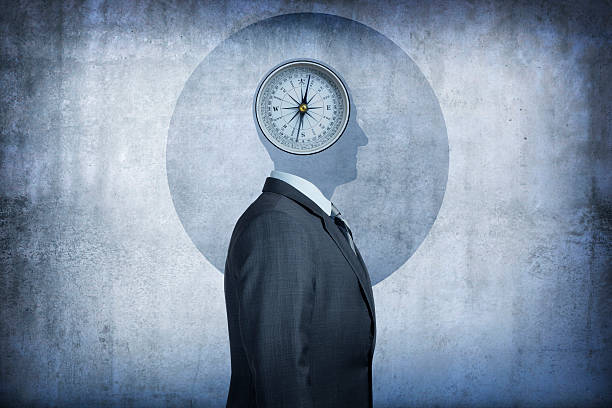 Moral compass concept A compass occupies the space over the man's head conveying the concept of morality and the choices we make. The man's head is reduced to its simple shape, devoid of any detail, and is silhouetted against the background. The man, dressed in a suit, stands at a profile to the camera. morality stock pictures, royalty-free photos & images