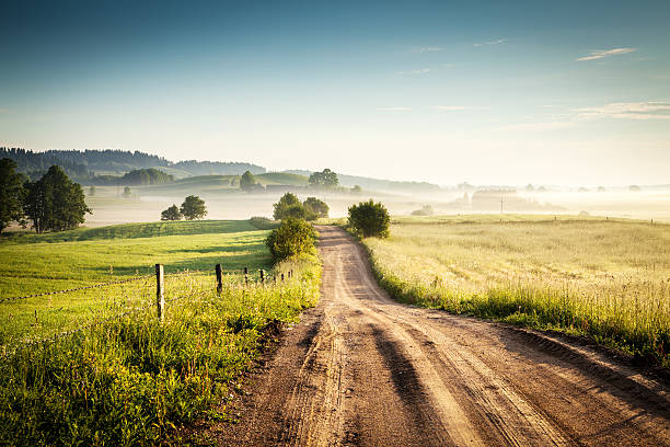 Morning Country Road through the Foggy Landscape - Colorful Countryside stock photo