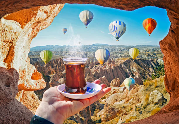 Morning cup of tea with view of colorful hot air balloons flying stock photo