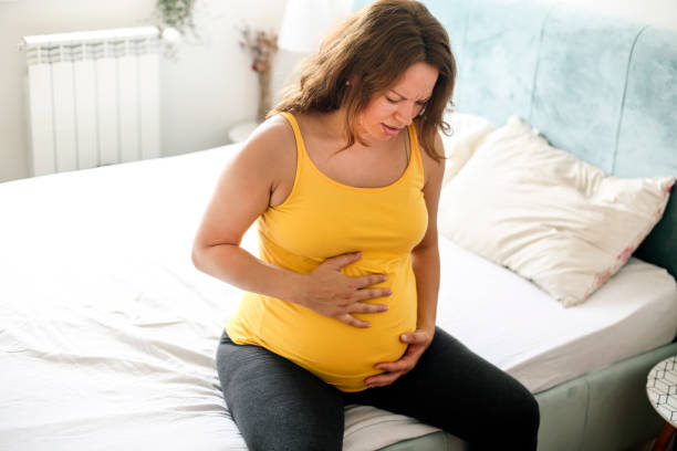 Morning sickness Pregnant woman feeling pain in her stomach. About 30 years old, Caucasian brunette. difficulties in pregnancy stock pictures, royalty-free photos & images