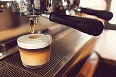 Marocchino coffee. Close-up shot of a coffee machine pouring coffee into glass.
