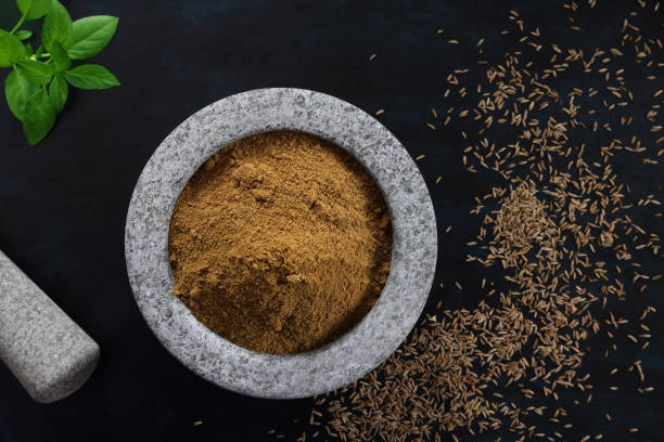 Mortar and Pestle Marble Mortar and Pestle with Cumin seeds and powder with a black background and copy space on right. Taken with Canon R5 producing 45 Megapixels cumin stock pictures, royalty-free photos & images