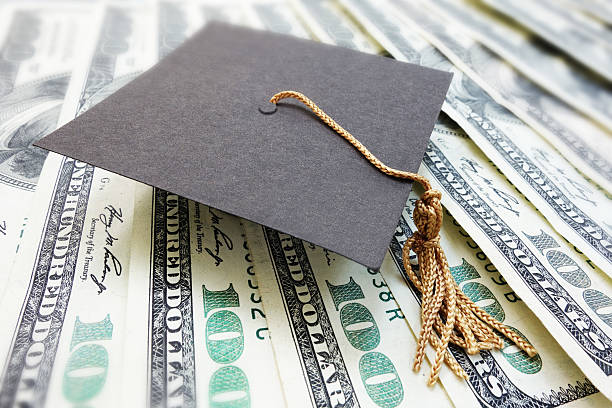 mortar board cash closeup of a mini graduation cap on cash student loan stock pictures, royalty-free photos & images