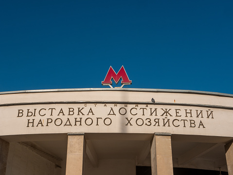 Moscow, Russia - October 7, 2021: Moscow metro, VDNKh station - exhibition of achievements of the national economy against the background of the blue sky. Close-up of the logo.