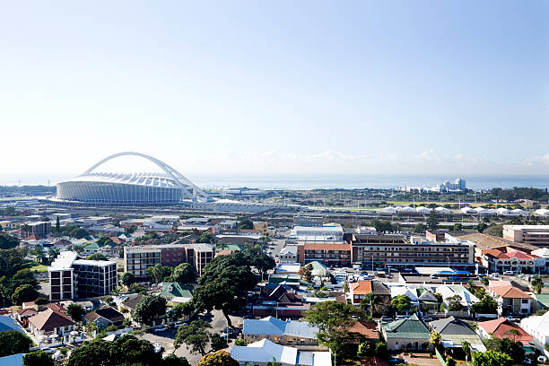 Moses Mabhida stadium Durban South Africa An elevated view of the old part of Durban with the new soccer world cup Moses Mabhida stadium in the backgound. The mid morning sun is to the left and there is a slight sea mist as the Indian Ocean is less than 300 meters away. Clear cloudless sky gives lots of copyspace.Here are other world cup images durban stock pictures, royalty-free photos & images