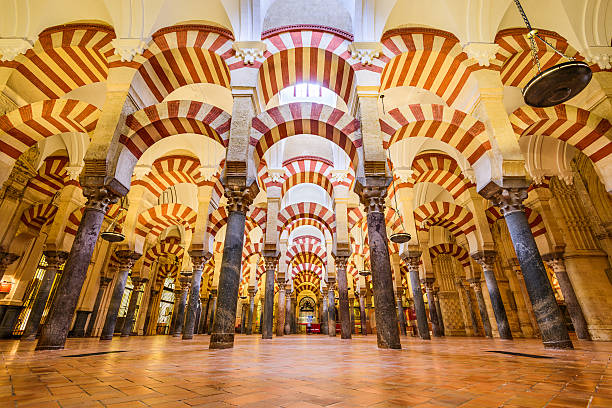 Mosque Cathedral Cordoba, Spain - November 10, 2014: Visitors observe the Hypostyle Hall in the Mosque-Cathedral of Cordoba. Though now used as a Catholic Cathedral, the building s regarded as one of the most accomplished monuments of Moorish architecture. cordoba mosque stock pictures, royalty-free photos & images