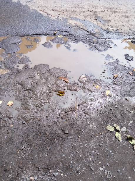 Most of the causes of water puddles on the edge of the highway are because there are holes in the road stock photo