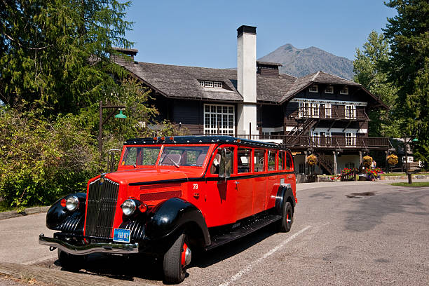 Red Jammer Bus at Lake McDonald Lodge Glacier National Park, Montana, USA - August 12, 2013: Most of the red "Jammer" buses are restored originals that have been on tour in the park since the 1930's. This bus waits for passengers in front of the historic Lake McDonald Lodge. jeff goulden montana stock pictures, royalty-free photos & images