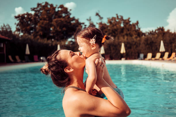 Mother and baby girl at swimming pool stock photo
