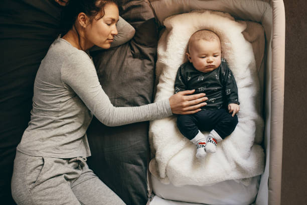 moeder en baby slapen - cradle to cradle stockfoto's en -beelden