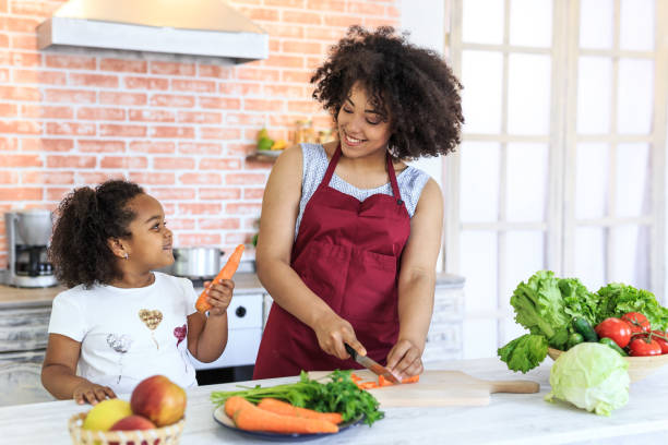 mother and child preparing healty meal - woman chopping vegetables imagens e fotografias de stock