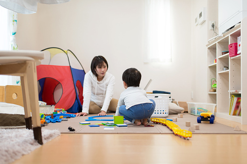 ✓ Imagen de Madre embarazada y el niño jugando con juguetes en la  habitación desordenada Fotografía de Stock