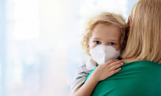 madre e bambino con maschera facciale e disinfettante per le mani - pandemia malattia foto e immagini stock