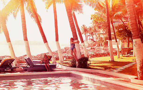 Mother and daughter by the swimming pool Vintage image of a mother and her daughter at sunset by the swimming pool on a summer vacation of the seventies / eighties. mexico photos stock pictures, royalty-free photos & images