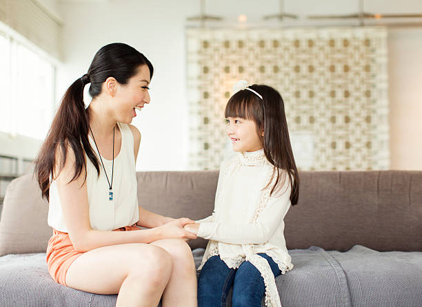 Mother and Daughter Conversation A young Chinese mother has a interesting conversation with her daughter. asian mother talking with daughter stock pictures, royalty-free photos & images