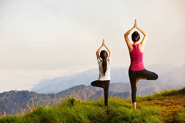 Mother and daughter doing yoga Mother and daughter doing yoga at top of mountain relaxation exercise photos stock pictures, royalty-free photos & images