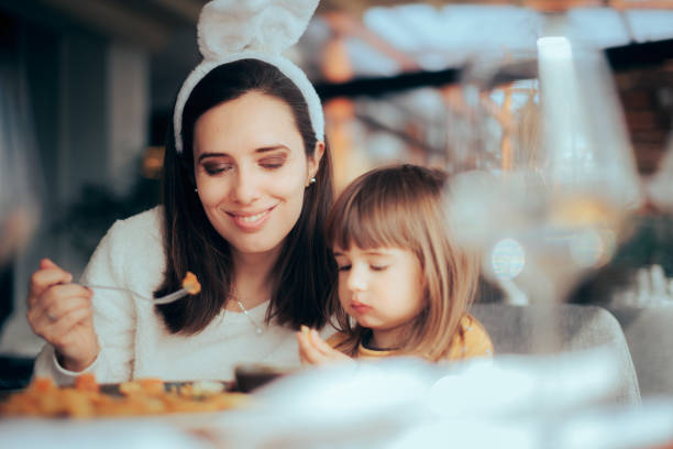 Mother and Daughter Eating Together Celebrating Easter stock photo